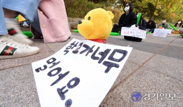27일 오전 인천시교육청 정문 앞에서 초등학교 원거리 배정 반대집회에 참석한 서구 청라 에일린의 뜰 학부모비대위 회원들이 아이들이 직접 쓴 메세지를 단 인형들을 사이에 놓고 사회적 거리두기를 하고 있다. 장용준기자