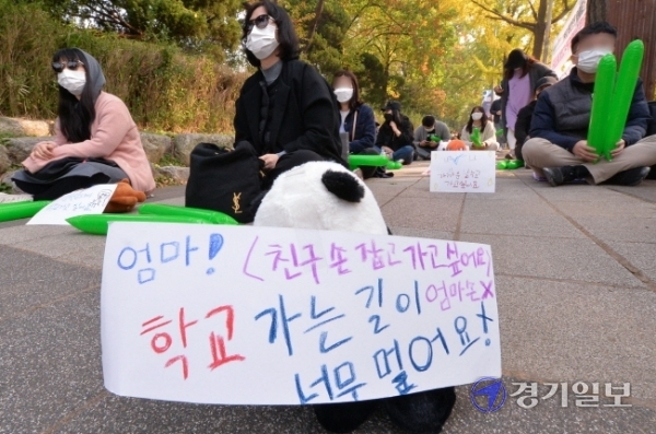27일 오전 인천시교육청 정문 앞에서 초등학교 원거리 배정 반대집회에 참석한 서구 청라 에일린의 뜰 학부모비대위 회원들이 아이들이 직접 쓴 메세지를 단 인형들을 사이에 놓고 사회적 거리두기를 하고 있다. 장용준기자