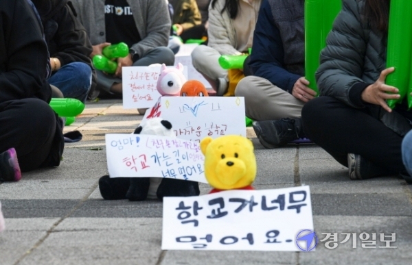 27일 오전 인천시교육청 정문 앞에서 초등학교 원거리 배정 반대집회에 참석한 서구 청라 에일린의 뜰 학부모비대위 회원들이 아이들이 직접 쓴 메세지를 단 인형들을 사이에 놓고 사회적 거리두기를 하고 있다. 장용준기자