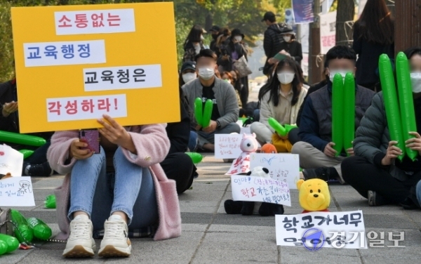 27일 오전 인천시교육청 정문 앞에서 초등학교 원거리 배정 반대집회에 참석한 서구 청라 에일린의 뜰 학부모비대위 회원들이 아이들이 직접 쓴 메세지를 단 인형들을 사이에 놓고 사회적 거리두기를 하고 있다. 장용준기자