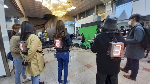 ▲ 오프라인 체험 관객이 번호가 적힌 카메라를 들고 대기하고 있다.