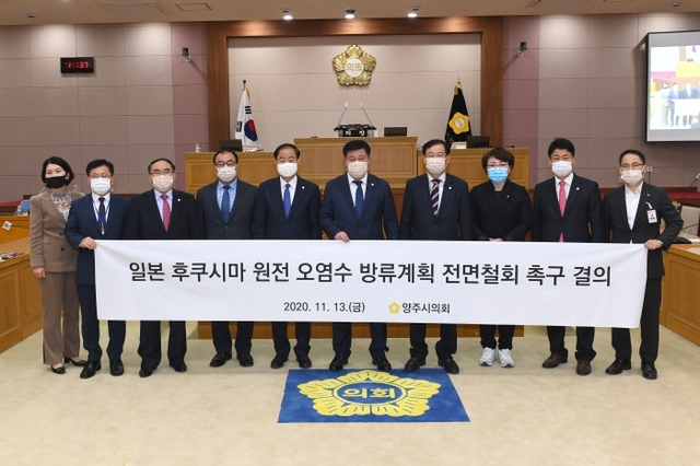 정덕영 의장을 비롯한 양주시의원들이 13일 본회의장에서 ‘일본 후쿠시마 원전 오염수 방류계획 전면철회 촉구 결의안’을 만장일치로 채택한 뒤 기념촬영을 하고 있다. 양주시의회 제공