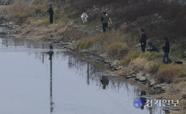 환경부와 농림축산식품부가 이천시 복하천에서 채취한 야생조류 포획 시료에서 H5N8형 고병원성 조류인플루엔자(AI)가 확진됐다고 밝힌 14일 오후 이천시 복하천 철새도래지 출입금지 구역에서 낚시꾼들이 낚시를 하고 있다. 조주현기자