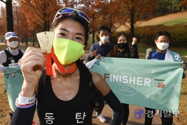 '제18회 경기마라톤 언텍트레이스대회' 삼일째인 14일 오전 박소영씨가 하프코스를 완주 한 뒤 메달을 들고 동탄마라톤클럽 동료들과 기념촬영을 하고 있다. 조주현기자