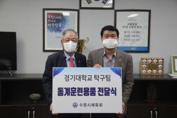 박광국 수원시체육회장(왼쪽)이 18일 정명권 경기대 체육실장에게 탁구부 훈련용품을 전달한 뒤 기념촬영을 하고 있다.수원시체육회 제공