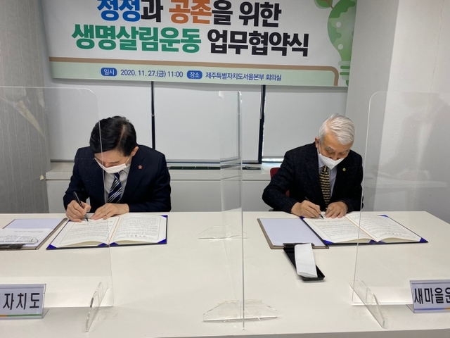 ▲ 정성헌 새마을운동중앙회장과 원희룡 제주특별자치도지사가 지난 27일 생명살림운동 전개를 위해 손을 모으고 업무 협약서에 서명하고 있다. 새마을운동중앙회 제공