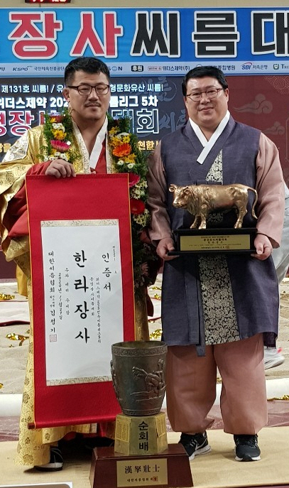 29일 문경체육관에서 열린 2020 민속씨름리그 5차 문경장사씨름대회 한라급에서 생애 첫 우승을 차지한 우형원(왼쪽)이 장사 인증서를 들고 장덕제 감독과 기념촬영을 하고 있다.용인백옥쌀 제공