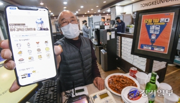 경기도 공공배달앱인 '배달특급'의 시범 서비스 시작을 하루 앞둔 30일 오후 파주시 문산읍 낙지요리전문점인 통큰낙지에서 상인 박찬범씨(74)가 배달특급 앱을 들어보이고 있다. 박씨는 