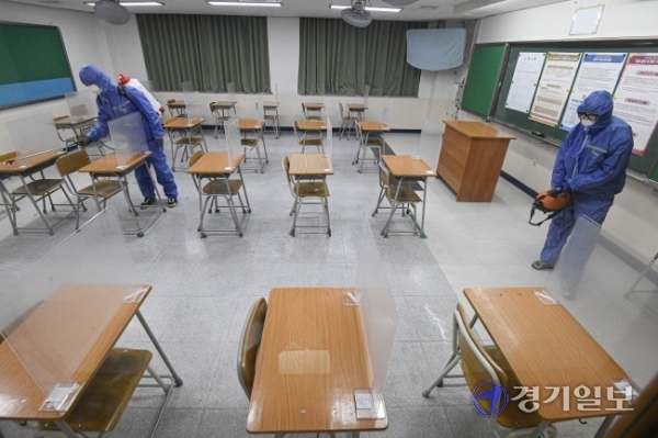 2021학년도 대학수학능력시험을 하루 앞둔 2일 오후 수원시 A고등학교에 마련된 시험실에서 방역 관계자들이 소독을 하고 있다. 조주현기자