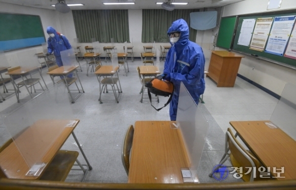 2021학년도 대학수학능력시험을 하루 앞둔 2일 오후 수원시 A고등학교에 마련된 시험실에서 방역 관계자들이 소독을 하고 있다. 조주현기자