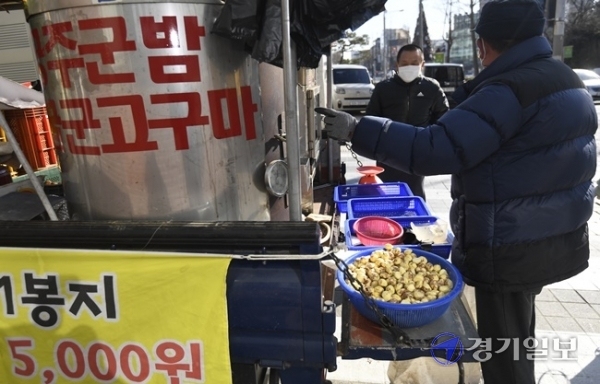 올겨울 들어 가장 추운 날씨를 보인 4일 오후 수원시 권선구 한 거리에서 상인이 군고구마와 군밤을 팔고 있다. 상인은 “군고구마는 날씨가 추울수록 잘 팔려요