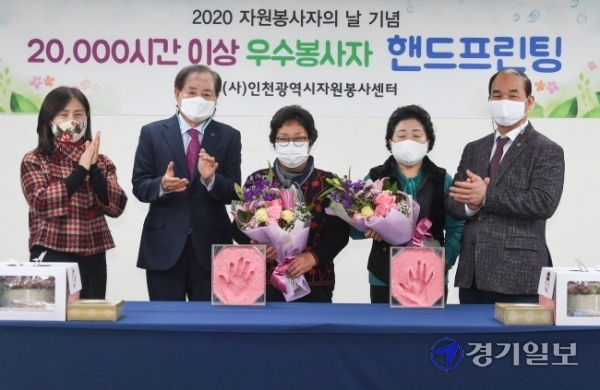 7일 인천시자원봉사센터 세미나실에서  동구자원봉사센터 강윤숙씨(왼쪽 3번)와 서구자원봉사센터 이춘자씨(왼쪽 4번)가 핸드 프린팅을 하며 전년성 인천시자원봉사센터 이사장(왼쪽2)의 격려속에 '2만 시간 우수 봉사'를 자축하고 있다. 장용준기자