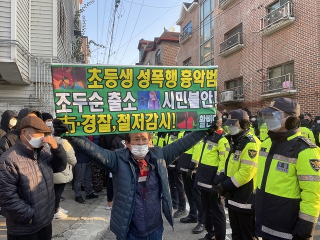 아동 성폭행범 조두순(68)이 12년만에 안산으로 돌아온 12일 오전 안산시 단원구의 한 주택가에서 그의 출소에 분노한 시민들과 경찰들이 대치하고 있다.