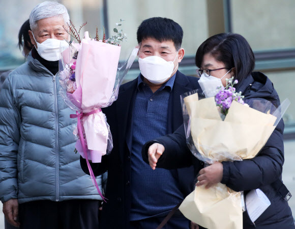 17일 오후 경기도 수원시 영통구 수원지방법원에서 열린 이춘재 연쇄살인 8차 사건 재심 선고공판에서 재심 청구인 윤성여 씨가 무죄를 선고받고 법원 청사를 나와 꽃다발을 받고 환하게 웃고 있다. 연합뉴스