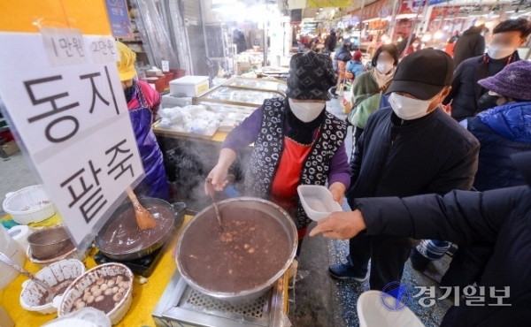 밤의 길이가 가장 길다는 동지(冬至)인 21일  인천 부평깡시장에서 시민들이 팥죽을 사가고 있다. 10년째 팥죽을 팔고 있다는 가게 주인은 