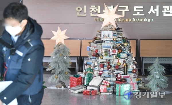 22일 오전 인천시북구도서관 신관 1층 로비에 설치돼 있는 ‘소망의 별’ 북 트리가 오가는 이용객들의 시선을 붙잡고 있다. 북구도서관은 성탄절과 연말연시를 맞아 1천권의 폐기 예정 도서  활용해 트리를 제작했다. 장용준기자