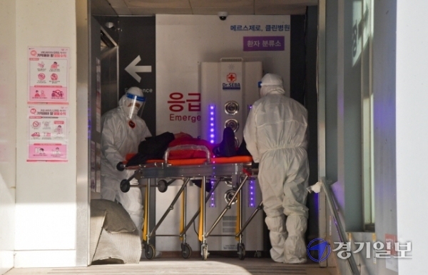 24일 오후 코로나19 거점 전담병원으로 전환된 뒤 운영을 시작한 평택시 박애병원에서 관계자들이 코로나19 확진자를 이송하고 있다. 윤원규기자