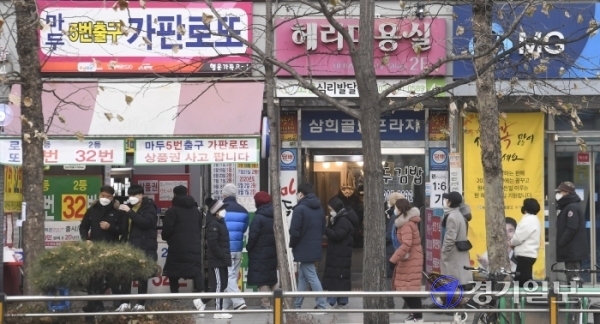 ▲ 새해 첫 로또복권 추첨일인 2일 오후 일산시 복권명당으로 불리는 한 판매점 앞에 복권을 사려는 시민들로 긴 줄이 늘어서 있다. 조주현기자