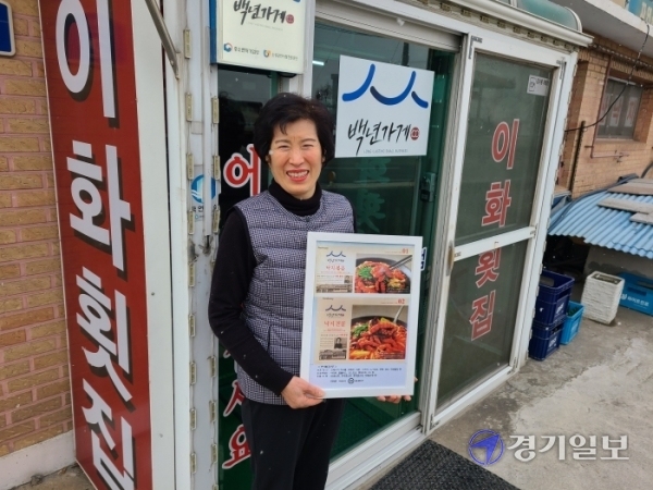 박영숙 이화횟집 대표(67)가 '백년가게 밀키트' 사진을 들고 웃음지어 보이고 있다. 김태희기자