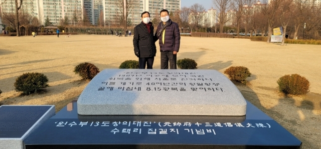 ▲ 안승남 구리시장(오른쪽)이 김문경 13도창의군 기념사업추진위원장과 수택동 장자호수공원에 설치된 13도창의군 기념물 앞에서 기념촬영을 하고 있다. 구리시 제공