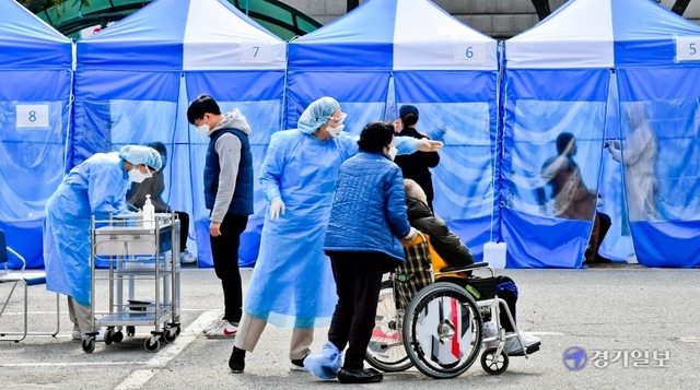 한 간호사가 코로나19 진단 검사를 위해 선별진료소를 찾은 시민을 안내하고 있다. 조주현ㆍ윤원규기자