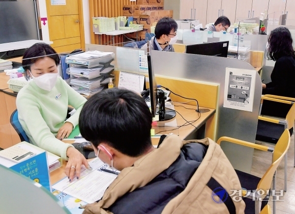 4일 오전 새해 첫 업무를 시작한 경기신용보증재단 성남지점에서 최민호 지점장이 직원들과 회의를 하고 있다.(사진 위) 직원들이 소상공인들과 상담을 하고 있다. 윤원규기자