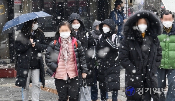 12일 오후 인천 미추홀구 경인전철 주안역 앞에서 시민들이 갑작스레 쏟아지는 눈을 맞으며 발걸음을 재촉하고 있다. 장용준기자