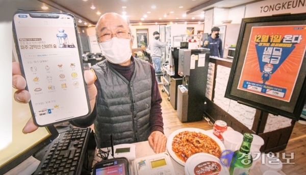 파주시 문산읍 낙지요리전문점인 통큰낙지에서 상인 박찬범씨(74)가 배달특급 앱을 들어보이고 있다.  조주현기자