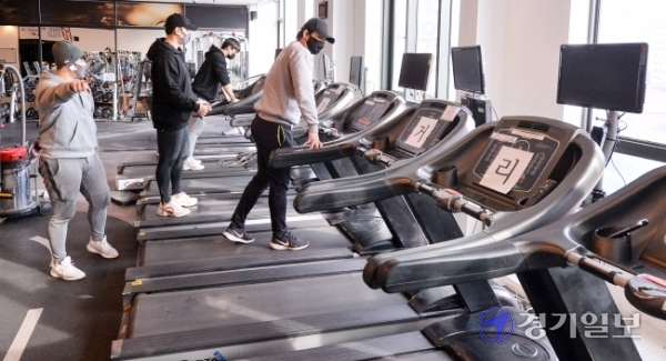 17일 오후  운영 재개를 하루 앞둔 경기도 용인시의 한 헬스장에서 관계자들이 운동기구들을 거리두기 재배치를 하고 있다. 오는 18일부터 수도권의 실내체육시설과 노래연습장 등 다중이용시설은 면적 8㎡(약 2.4평)당 이용 인원을 1명으로 제한해 오후 9시까지 운영을 할 수 있다. 장용준기자
