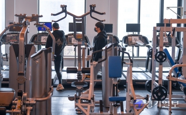 17일 오후  운영 재개를 하루 앞둔 경기도 용인시의 한 헬스장에서 관계자들이 운동기구들을 거리두기 재배치를 하고 있다. 오는 18일부터 수도권의 실내체육시설과 노래연습장 등 다중이용시설은 면적 8㎡(약 2.4평)당 이용 인원을 1명으로 제한해 오후 9시까지 운영을 할 수 있다. 장용준기자