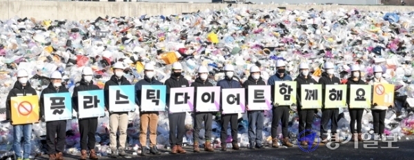 19일 오전 수원시자원순환센터 플라스틱 야외적치장에서 수원도시공사 임직원들이 '플라스틱 다이어트 함께 해요' 문구가 새겨진 피켓을 들고 '탈 플라스틱 캠페인'을 하고 있다.장용준기자
