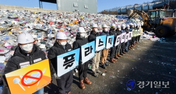 19일 오전 수원시자원순환센터 플라스틱 야외적치장에서 수원도시공사 임직원들이 '플라스틱 다이어트 함께 해요' 문구가 새겨진 피켓을 들고 '탈 플라스틱 캠페인'을 하고 있다.장용준기자