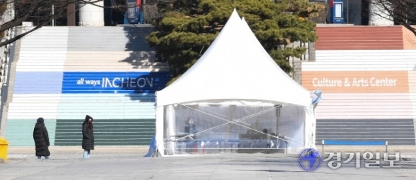 꽃샘추위가 몰아친 2일 오전 인천종합문예회관 광장에 설치한 코로나19 남동구 임시 선별 검사소에서 핫팩을 손에 쥔 의료진들이 난로 앞에서 언몸을 녹이고 있다.장용준기자