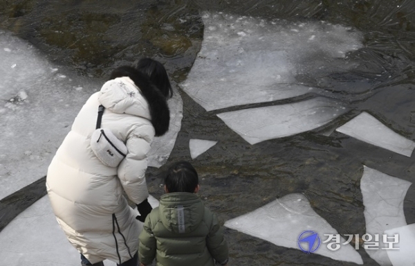 포근한 날씨를 보인 5일 오후 수원시 수원천변에서 한 가족이 얼음이 녹기 시작한 하천을 신기한 듯 바라보고 있다. 기상청은 다음주부터 평년기온보다 5~10도 정도 높은 포근한 날씨가설 연휴가 끝나는 오는 14일까지 계속될 것으로 전망했다. 조주현기자