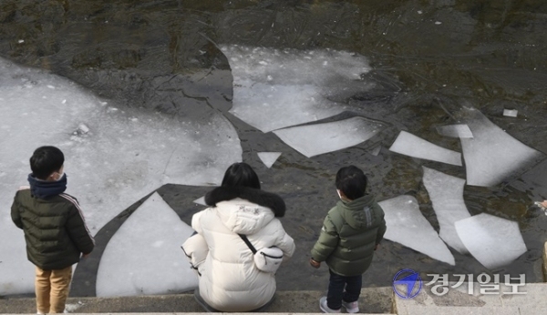 포근한 날씨를 보인 5일 오후 수원시 수원천변에서 한 가족이 얼음이 녹기 시작한 하천을 신기한 듯 바라보고 있다. 기상청은 다음주부터 평년기온보다 5~10도 정도 높은 포근한 날씨가설 연휴가 끝나는 오는 14일까지 계속될 것으로 전망했다. 조주현기자