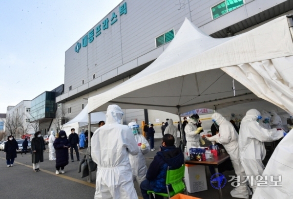 코로나19 집단감염이 발생한 남양주시 플라스틱 제조업체 앞에 설치된 이동검사소에서 17일 오후 인근 업체 근로자들이 전수검사를 위해 줄 서 있다. 방역당국은 이 업체에서 현재까지 115명이 코로나19 확진 판정을 받아 산단 전체 근로자를 대상으로 전수검사를 하고 있다.조주현기자
