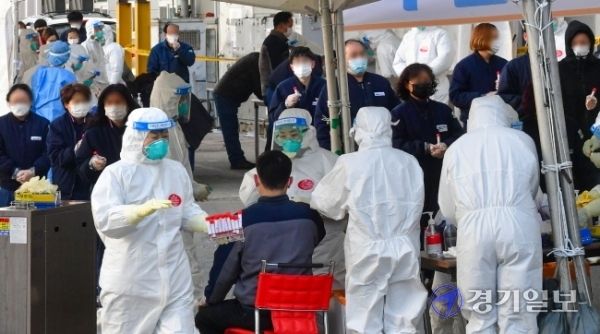 코로나19 집단감염이 발생한 남양주시 플라스틱 제조업체 앞에 설치된 이동검사소에서 17일 오후 인근 업체 근로자들이 전수검사를 위해 줄 서 있다. 방역당국은 이 업체에서 현재까지 115명이 코로나19 확진 판정을 받아 산단 전체 근로자를 대상으로 전수검사를 하고 있다.조주현기자