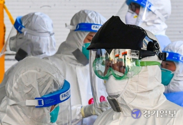 경기지역 기온이 영하 10도 밑으로 떨어지며 혹한의 날씨를 보인 17일 오후 남양주시 진관산단 내 설치된 임시검사소에서 의료진이 난로로 몸을 녹이며 추위와 싸우고 있다.조주현기자