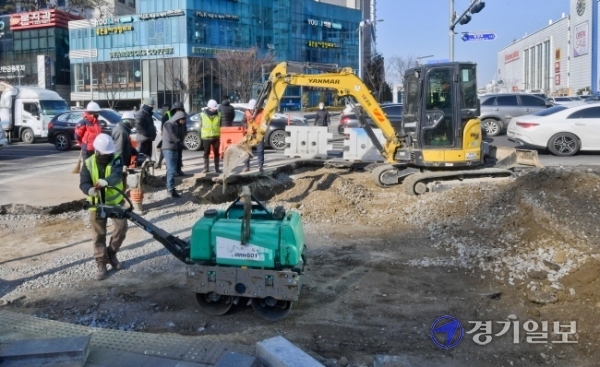 18일 오전 수원시청역 사거리의 도로에서 수원시 관계자들이 도로복구작업을 하고 있다. 지난 17일 오후 10시 40분께 도로 35m구간이 80cm 가량 침하돼 수원시는 곧바로 인근 도로를 통제후 복구작업을 진행했다. 윤원규기자