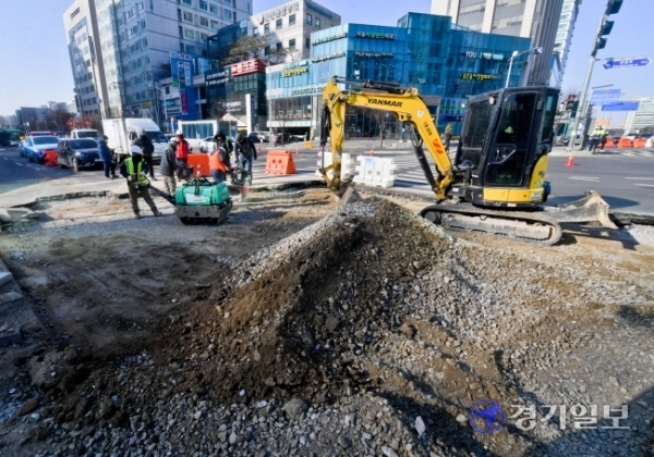 18일 오전 수원시청역 사거리의 도로에서 수원시 관계자들이 도로복구작업을 하고 있다. 지난 17일 오후 10시 40분께 도로 35m구간이 80cm 가량 침하돼 수원시는 곧바로 인근 도로를 통제후 복구작업을 진행했다. 윤원규기자