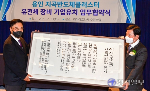 23일 오전 15일 수원시 라마다 프라다 수원 호텔에서 열린 '용인 지곡반도체클러스터 유전체 장비 기업 유치 업무협약식'에서 (왼쪽부터) 김언식 DSD그룹 회장과 김진표 의원이 기념품을 들어보이고 있다. 조주현기자