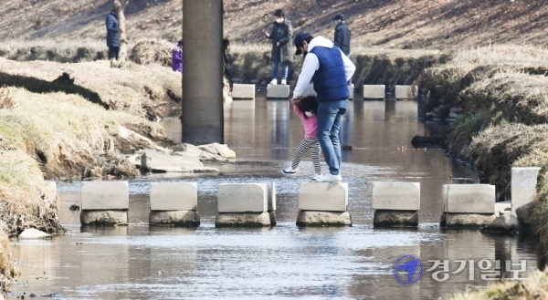 포근한 봄날씨를 맞은 지난 21일 오후 인천 부평구 굴포천에서 산책을 나선 한 일가족이 조심스레 징검다리를 건너고 있다. 장용준기자