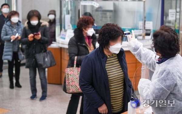 코로나19 백신 접종을 시작한 26일 오전 인천 부평구 부평구보건소에서 한 요양시설 관계자들이 백신 접종 접수에 앞서 발열검사를 받고 있다. 장용준기자