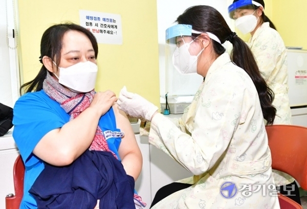 코로나19 백신 접종이 시작된 26일 오전 광명시보건소 접종실에서 첫 접종자인 강경희(52)씨가 백신 주사를 맞고 있다. 강씨는 “기쁘게 맞으러 나왔다. 축하합니다라는 인사를 서로 나눌 수 있었으면 좋겠다. 모두가 일상생활로 돌아가는 것을 희망한다”고 말했다. 조주현기자