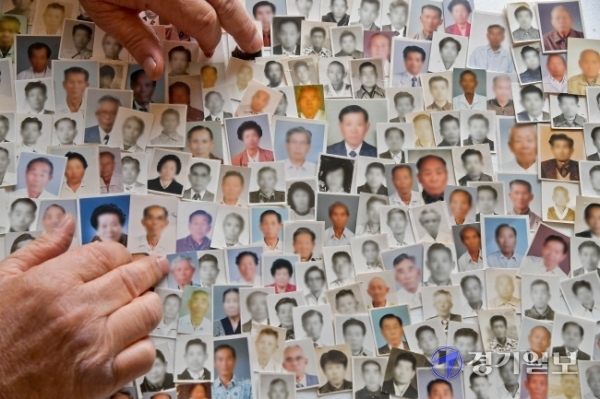 102주년 3·1절을 하루 앞둔 28일 평택시 비전동 사단법인 한국원폭피해자협회 기호지부 사무실에서 관계자가 원폭피해자 1세대들의 사진을 살펴보고 있다. 사진속 원폭피해자 1세대들은 모두 세상을 떠났다. 사진=윤원규기자