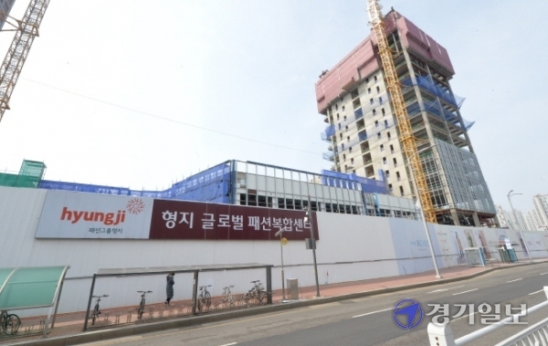 9일 인천 연수구 송도동 11의2 산업용지 일대에 들어서고 있는 ‘형지 글로벌패션복합센터’ 공사장 외벽에  꼼수 논란이 일고 있는 상가분양 홍보 현수막이 붙어 있다. 장용준기자