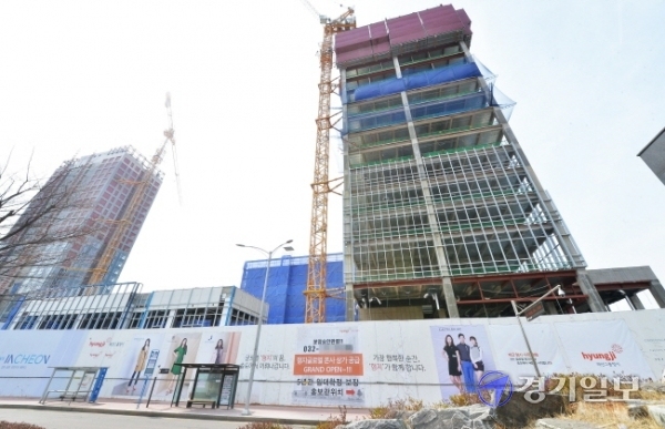 9일 인천 연수구 송도동 11의2 산업용지 일대에 들어서고 있는 ‘형지 글로벌패션복합센터’ 공사장 외벽에  꼼수 논란이 일고 있는 상가분양 홍보 현수막이 붙어 있다. 장용준기자
