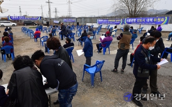 12일 오후 시흥시 과림동 하수종말처리장 부지에서 열린 '시흥광명 신도시 대책위원회 발대식'에서 참석자들이 설명을 듣고 있다.  이날 대책위는 광명시흥 3기 신도시 사업의 정상화와 LH 직원 및 정치인의 투기 의혹에 대한 철저한 조사 및 처벌, 공시지가 대비 2.5~3배 이상의 손실 보상을 요구했다. 조주현기자