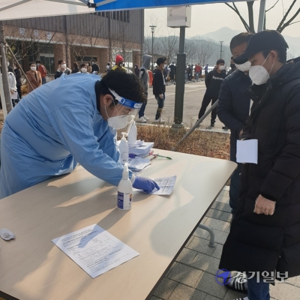 13일 오전 용인시 처인구 모현다목적복지회관에 설치된 임시선별진료소에서 외국인 이주노동자가 설문지 작성법을 안내받고 있다. 김현수기자