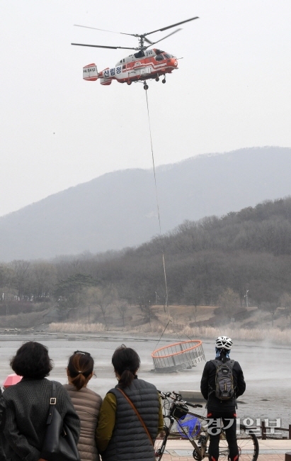 15일 오후 인천시 남동구 인천대공원에서 산림청 소방 헬기가 대형 저수조를 호수로 옮기고 있다. 전국 최초로 사계절 산불진화 헬기 담수용으로 제작한 지름 6m, 높이 1.9m 규모의 스테인리스 원형 그물망 형태의 저수조는 침전물과 결빙을 방지하는 특징을 갖고 있다. 장용준기자